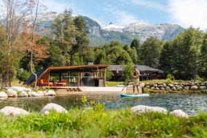 a man standing on a paddle board in the water at Peuma Lodge Patagonia in Futaleufú