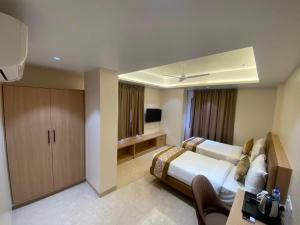 a hotel room with a bed and a television at Hotel Banyan Crest in Solapur