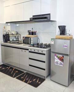 a kitchen with a stove and a refrigerator at Skyline Westlands with Gym in Nairobi