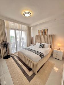 a bedroom with a large bed and a large window at Skyline Westlands with Gym in Nairobi