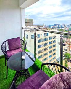 a balcony with a glass table and a chair at Skyline Westlands with Gym in Nairobi