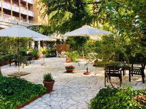 a patio with tables and umbrellas and chairs at Hotel Imperiale in Fiuggi