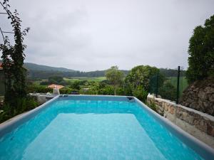 a blue swimming pool with a view of the mountains at Villa Santamaría in Muxia