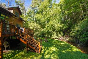 a deck on the side of a log cabin at Waterfall Cottage in Boone