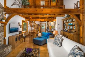 a living room with a white couch and wooden ceilings at Waterfall Cottage in Boone