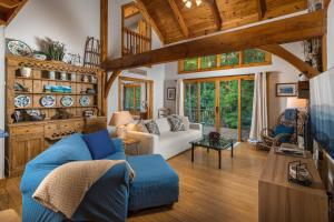 a living room with a blue couch and wooden ceilings at Waterfall Cottage in Boone