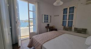 a bedroom with a bed and a view of the ocean at Panoramic View apartment in Poros