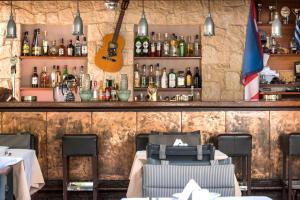 a restaurant with a bar with a guitar on the wall at Elotis Suites in Agia Marina Nea Kydonias