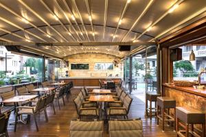 a restaurant with tables and chairs and a bar at Elotis Suites in Agia Marina Nea Kydonias