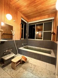 a bathroom with a bath tub and a shower at 熱海の貸切温泉宿 kintsugi プライベートサウナ BBQ in Atami +30 photos