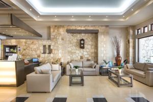a living room with couches and a stone wall at Elotis Suites in Agia Marina Nea Kydonias
