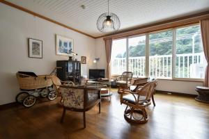a living room with a baby carriage and chairs at 熱海の貸切温泉宿 kintsugi プライベートサウナ BBQ in Atami