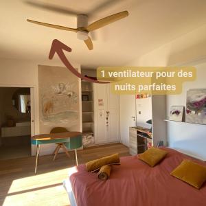 a room with a bed and a ceiling fan at Nature loft, calme et confortable in La Murette