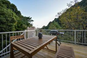 a wooden table on a deck with a grill on it at 熱海の貸切温泉宿 kintsugi プライベートサウナ BBQ in Atami