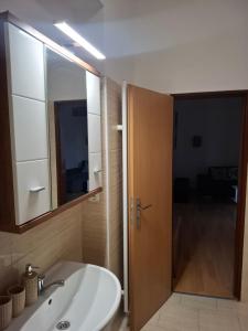 a bathroom with a sink and a wooden door at Apartmán u parku in Prostějov +37 photos