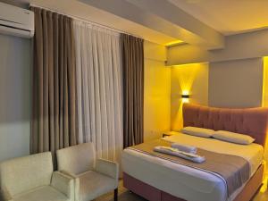 a hotel room with a bed and a chair at Silvercity Hotel&Suits in Eskisehir