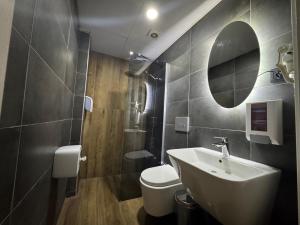a bathroom with a sink and a toilet and a mirror at Silvercity Hotel&Suits in Eskisehir +27 photos