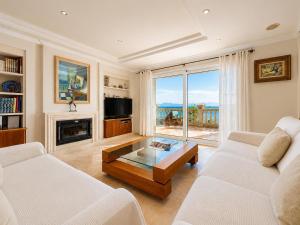 a living room with two white couches and a table at Villa Casa Faro in Alcanada