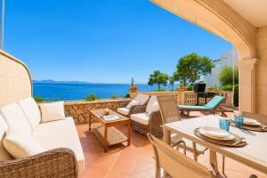 a patio with furniture and a view of the ocean at Villa Casa Faro in Alcanada