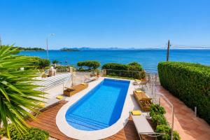 a swimming pool on a deck next to the ocean at Villa Casa Faro in Alcanada