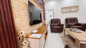 a office with two chairs and a desk and a tv at Saob Property in Germiston