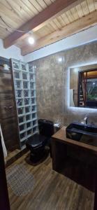 a bathroom with a toilet and a sink and a mirror at Cabaña El Dorado, Alojamiento in Puerto Cantera
