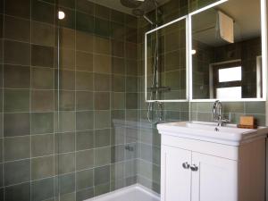 a bathroom with a sink and a mirror and a tub at Cottage on the Lane Dingle in Dingle +31 photos