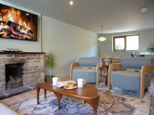 a living room with a fireplace and a table and chairs at Cottage on the Lane Dingle in Dingle