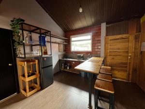 a small kitchen with a table and a refrigerator at Anagrama house in Baños +30 photos