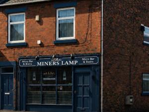 a brick building with a farmers loan sign on it at Miners Lamp Apartment in Easington