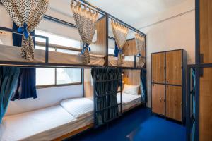 a room with three bunk beds in a bus at Arawana Hostel Silom in Bangkok +63 photos