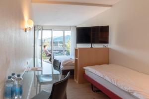 a hotel room with two beds and a glass table at Hotel Seaside in Spiez +82 photos