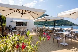 a deck with tables and chairs and umbrellas at Hotel Tirreno in Sapri