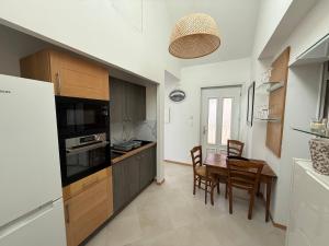 a kitchen and dining room with a table and chairs at Le Refuge du Saule in Saint-Aubin-de-Locquenay