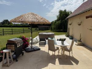 a patio with a grill and a table and chairs at Le Refuge du Saule in Saint-Aubin-de-Locquenay +13 photos