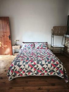 a bed with a quilt on it in a bedroom at Suite Central Campestre - Casa Matula in Popayan