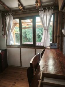 a long wooden table with chairs and a large window at Suite Central Campestre - Casa Matula in Popayan +12 photos