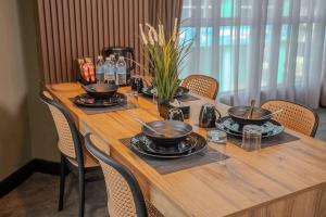 a wooden table with chairs and pots and pans on it at Hotel Valya Melaka Sentral Riverfront in Malacca
