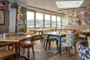 a restaurant with tables and chairs and windows at Havener's in Fowey