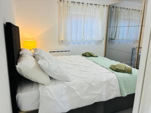 a bedroom with a large bed with white sheets and pillows at Cozy Grays Apartment in Grays Thurrock