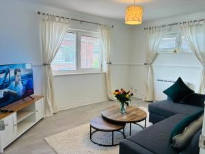 a living room with a couch and a tv at Cozy Grays Apartment in Grays Thurrock