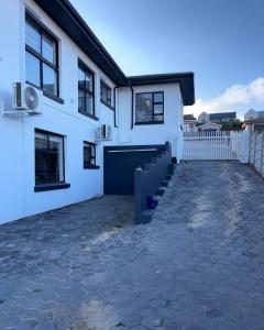 a white house with a driveway in front of it at Seashell Flat in Mossel Bay