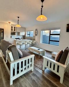 a living room with two couches and a kitchen at Seashell Flat in Mossel Bay