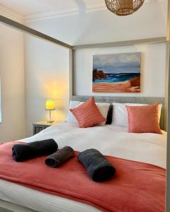 a bedroom with two beds with pillows on a red blanket at Seashell Flat in Mossel Bay