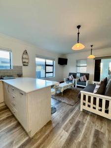 a kitchen and living room with a large white island at Seashell Flat in Mossel Bay