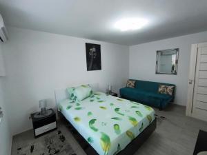 a bedroom with a bed and a blue couch at Apartament IRIS Băile Herculane in Băile Herculane