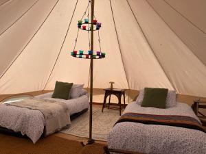 a room with two beds in a tent at Apuldram Roses in Appledram