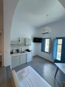 a kitchen with white cabinets and a table in it at Apollonia Studios in Katapola