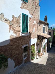 a brick building with a green window and a stairway at B&B Colle Degli Angeli in Penne