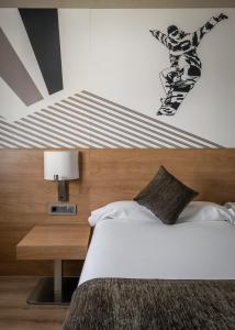 ein Schlafzimmer mit einem Bett mit einem Snowboard an der Wand in der Unterkunft Estival Sporting in Pas de la Casa